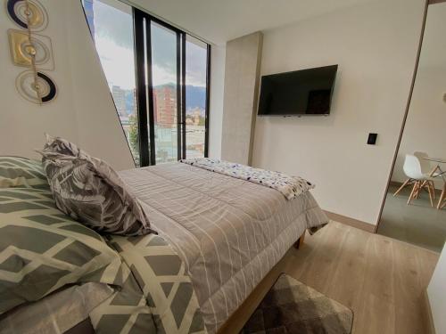 a bedroom with a bed and a large window at Suite de lujo con balcón en Edificio NEO in Quito