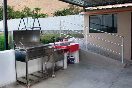 a grill on a patio next to a building at Kampu Wasi - Casa de Campo in Pachacamac