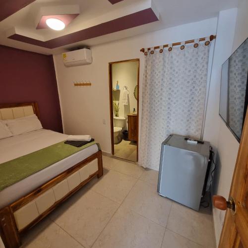 a bedroom with a bed and a door to a bathroom at Dreimar Hotel Boutique in Cartagena de Indias