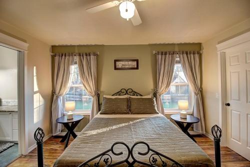 a bedroom with a large bed with two windows at Whitefish Luxury Escape w hot tub, fenced in yard in Whitefish