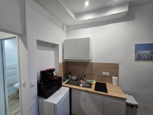 une cuisine avec un évier et un plan de travail dans l'établissement E1 - Charmant studio en intramuros, rénové climatisé, à Avignon