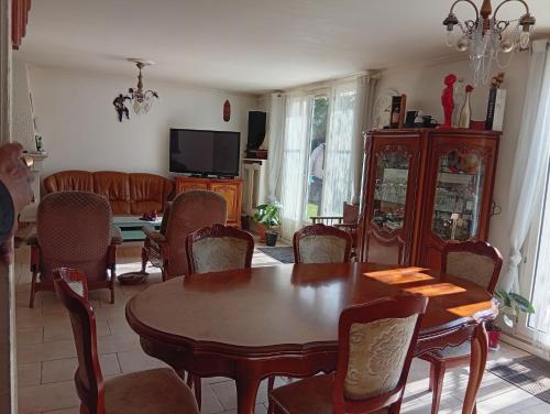 un salon avec une table et des chaises en bois dans l'établissement Villa grand confort proche Versailles et Paris, à Guyancourt