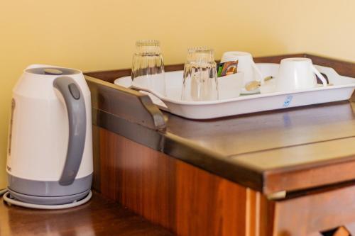 a counter with a coffee maker and a tray on it at Karen Plains Hotel Nairobi in Nairobi