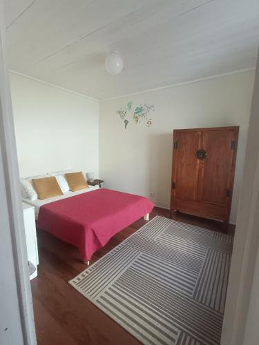 a bedroom with a bed with a pink blanket at Casa dos Narizes in Angra do Heroísmo