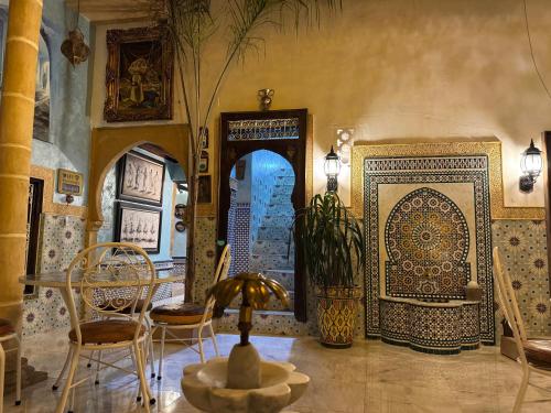 a dining room with a table and chairs and a wall at RIAD ESMERALDA By Dar Ouezzani in Rabat