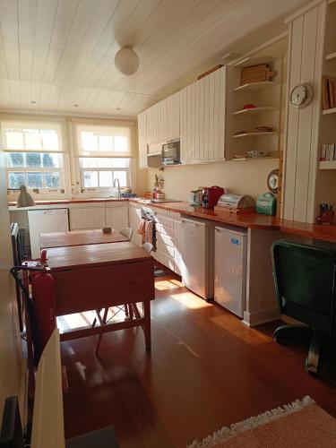a kitchen with a wooden table and a wooden floor at Casa dos Narizes in Angra do Heroísmo