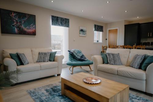 a living room with two couches and a coffee table at Stanloch Barn - new barn conversion, well equipped, EV in Glencaple