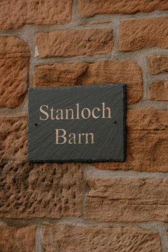 a sign on the side of a brick wall at Stanloch Barn - new barn conversion, well equipped, EV in Glencaple