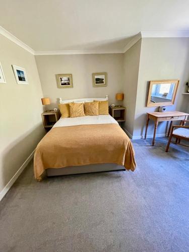 a bedroom with a bed and a desk in it at Lundie View B & B in Invergarry
