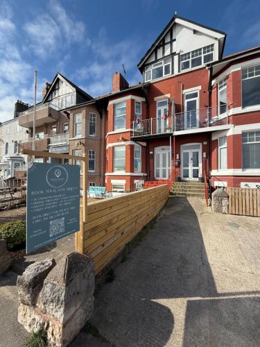 un edificio con un cartello davanti di Stunning 2 Bedroom Beach Apartment With Garden a Rhos-on-Sea