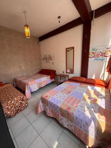 a bedroom with two beds and a mirror at México Lindo in Mexico City