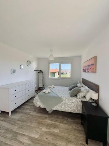 a bedroom with a large bed and a dresser at Villa Ikigai Costa in Villaviciosa
