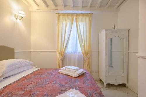 a bedroom with a large bed and a window at Domus Nannini SPA - L' Arco di Matteotti in Siena