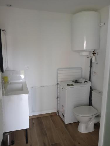 a white bathroom with a toilet and a sink at Maison partagée - Studio bas in Beauvais