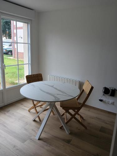 a white table and two chairs in a room at Maison partagée - Studio bas in Beauvais
