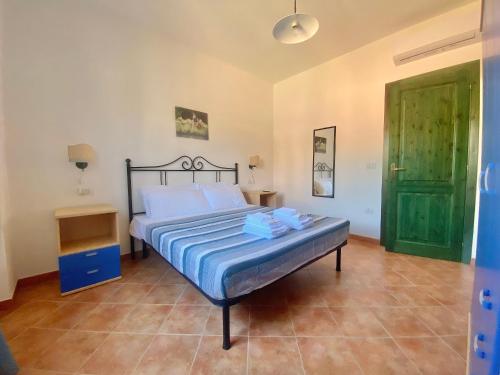 a bedroom with a bed and a green door at Sos Alinos - Cala Liberotto - Orosei - Apartment 4 in Cala Liberotto