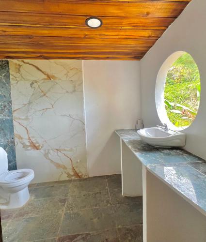 a bathroom with a toilet and a window at Puerto Alto Hostel in Santa Marta