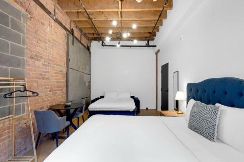 a bedroom with a large bed and a brick wall at The Little Prince Rooms-Old Montreal in Montréal
