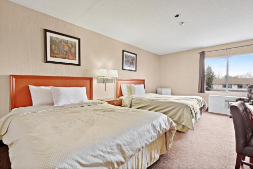 a hotel room with two beds and a window at Niagara Lodge & Suites in Niagara Falls