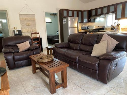 a living room with a leather couch and a table at Luxurious One Bedroom Poolside Punta Chame Resort in Pajonal