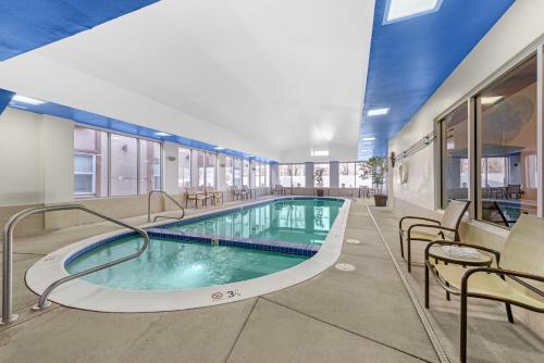 a large swimming pool in a building with chairs at Best Western Executive Inn & Suites in Colorado Springs