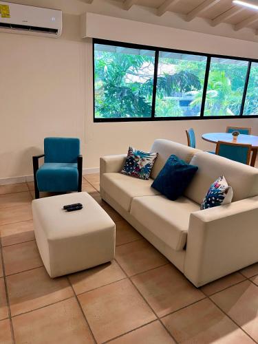 a living room with a couch and a chair at Private Resort Suite, Hotel Amenities & Golf in Las Lajas