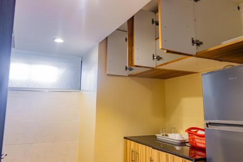 a kitchen with yellow walls and white cabinets at Karen Plains Hotel Nairobi in Nairobi