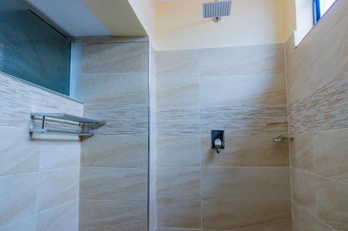 a shower with a glass door in a bathroom at Karen Plains Hotel Nairobi in Nairobi