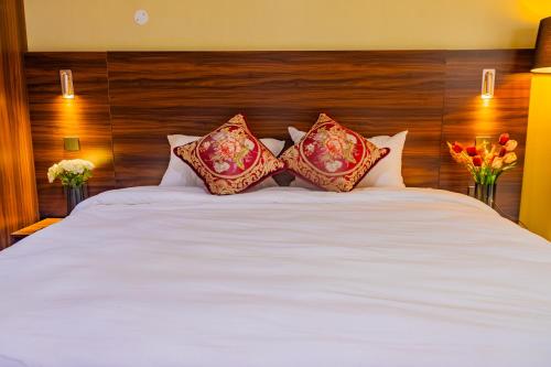 a large white bed with four pillows on it at Karen Plains Hotel Nairobi in Nairobi