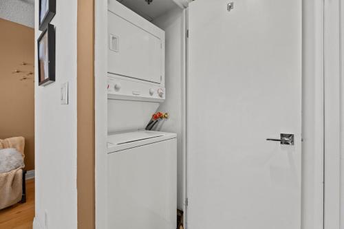 a white refrigerator in a kitchen next to a door at Cozy Apartment at Dundas Square! in Toronto