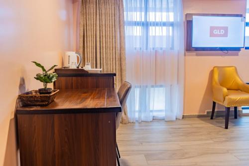 a waiting room with a tv and a yellow chair at Karen Plains Hotel Nairobi in Nairobi
