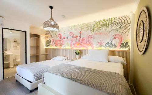 two beds in a bedroom with a mural of flamingos at Casana Rosa Hotel in Santa Marta