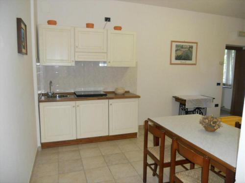 a kitchen with white cabinets and a table at Agriturismo La Selva in Nocera Umbra