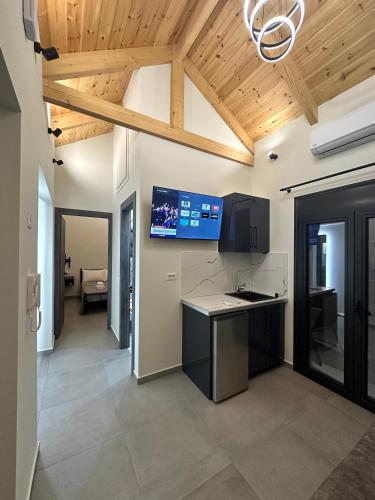 a kitchen with a ceiling with a tv on the wall at Golden Ecco Suites in Nafpaktos