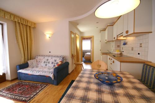 a living room with a couch and a kitchen at Appartamenti Residence Pars in Badia