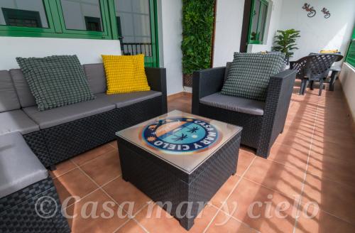 a patio with a couch and chairs and a table at Casa mar y cielo in Playa Blanca