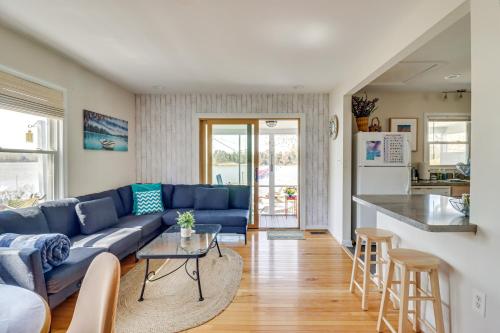 a living room with a blue couch and a kitchen at Potomac River Getaway Walk to Marina! in King George
