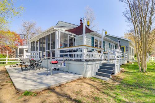 a large white house with a table and chairs at Potomac River Getaway Walk to Marina! in King George