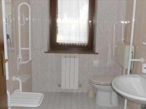 a bathroom with a toilet and a sink and a window at Agriturismo La Selva in Nocera Umbra