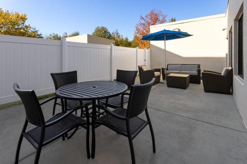 a patio with a table and chairs and an umbrella at Holiday Inn Express Harrisburg I-81 - Hershey By IHG in Manadahill
