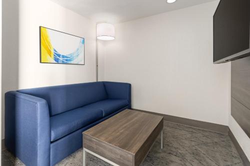 a living room with a blue couch and a table at Holiday Inn Express Harrisburg I-81 - Hershey By IHG in Manadahill