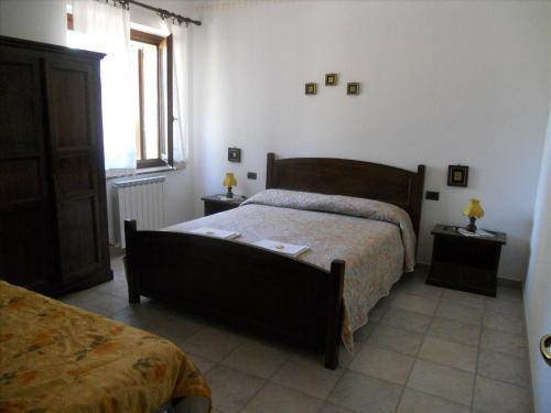 a bedroom with a bed and two end tables with lamps at Agriturismo La Selva in Nocera Umbra