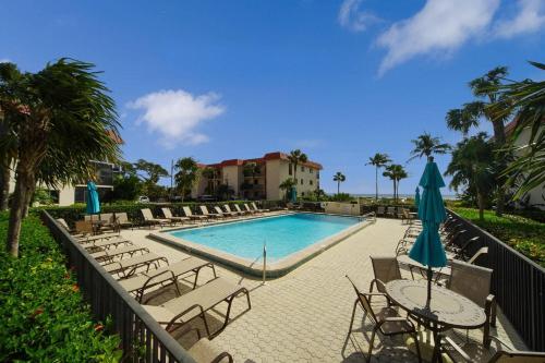 a pool with chairs and tables and umbrellas at 1BR ocean view condo on Sanibel Island Steps from the beach 3B3 in Sanibel
