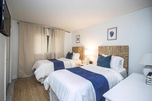 two beds in a hotel room with white and blue sheets at Spacious 2BR Condo With Beach Views Sanibel Island 1C2 in Sanibel