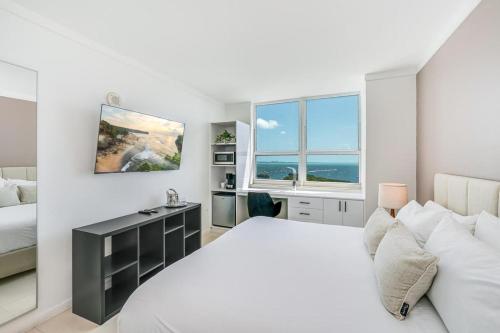 Un dormitorio blanco con una cama y un escritorio. en Coconut Grove Bayview unit Parking Included, en Miami