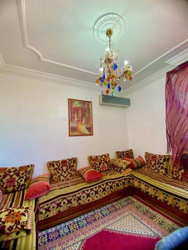 a living room with a couch and a chandelier at Luxury Stay Agadir Center in Agadir