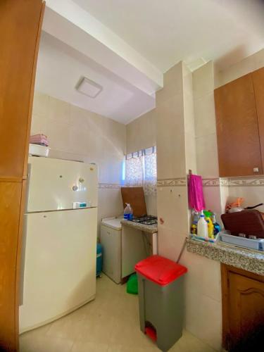 a kitchen with a white refrigerator and a red stool at Luxury Stay Agadir Center in Agadir