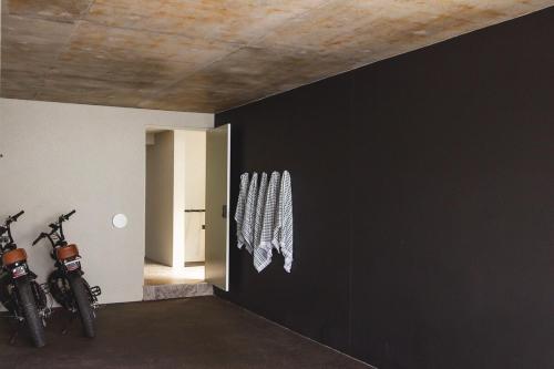 two motorcycles parked in a room with a black wall at NACRE curated luxury - steps to the beach - heated pool in Marcoola