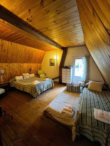 a large room with two beds and a wooden ceiling at Casa en Potrerillos in Potrerillos