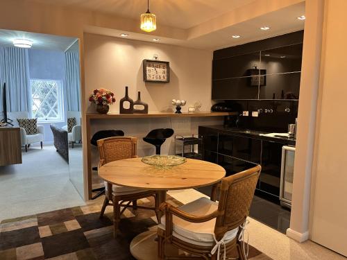 a kitchen with a table and chairs in a room at Center Suiço Flats in Campos do Jordão